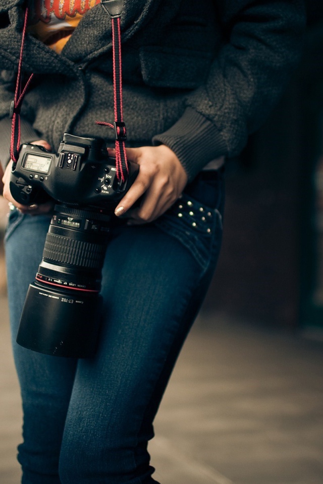 Девушка фотограф с профессиональным фотоаппаратом Canon