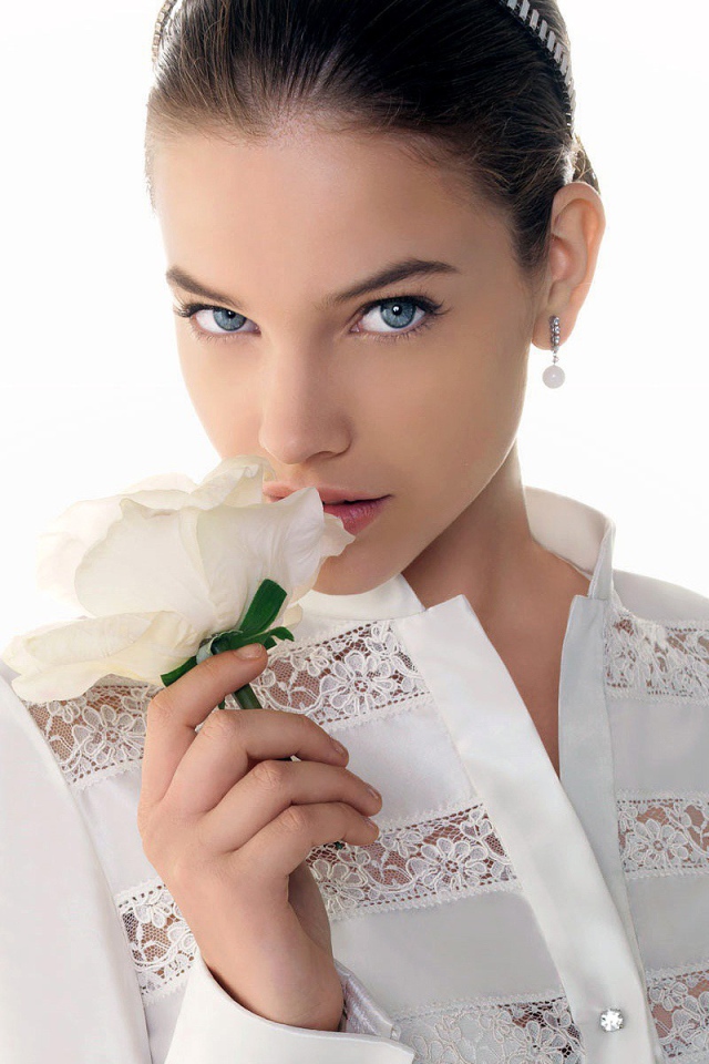 Девушка нюхает белый цветок