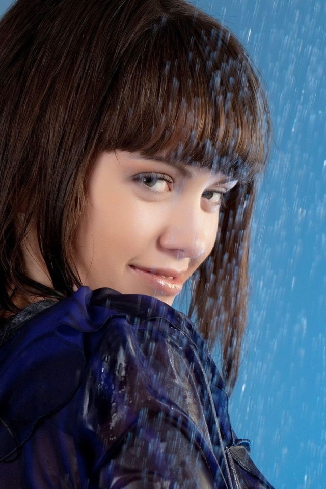 Девушка стоит под струей воды