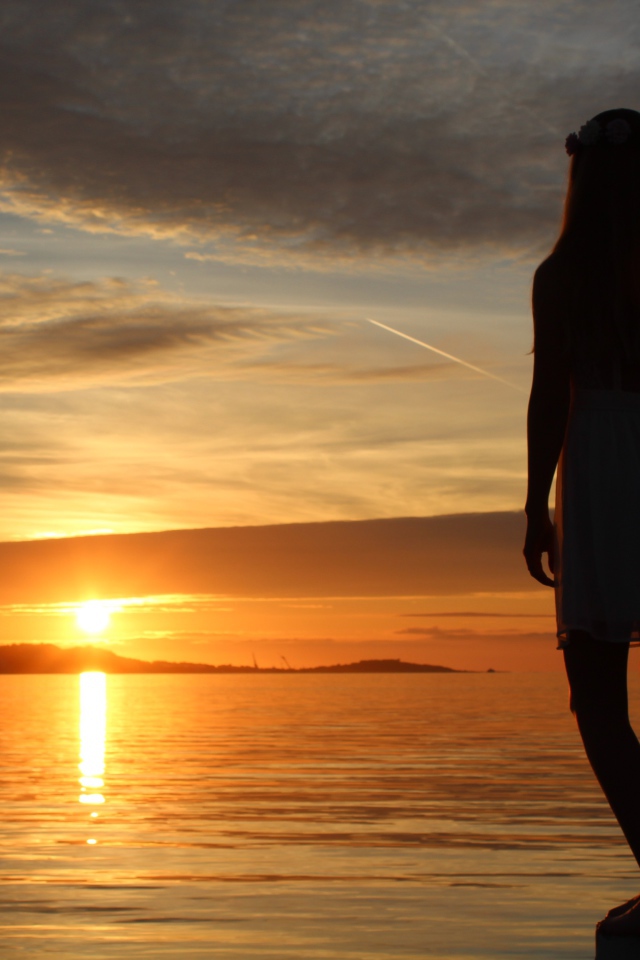 Девушка смотрит на закат в Норвегии