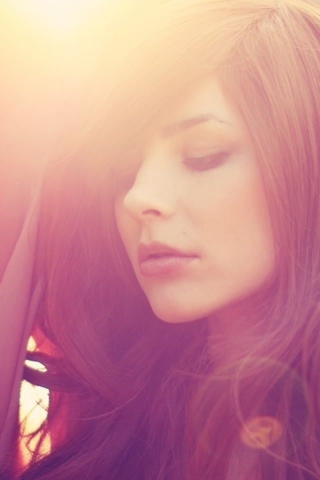 Девушка с каштановыми волосами в лучах солнца