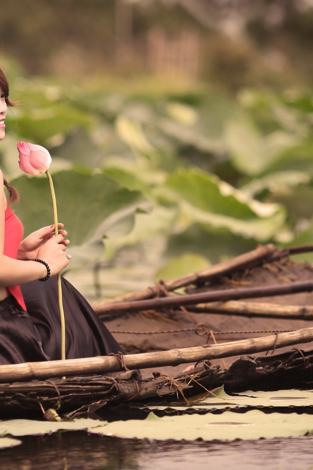Девушка с цветком сидит в лодке