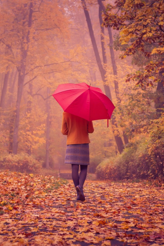 Девушка с красным зонтом идет по аллее