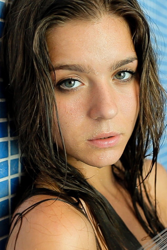 Зеленоглазая брюнетка стоит в душе