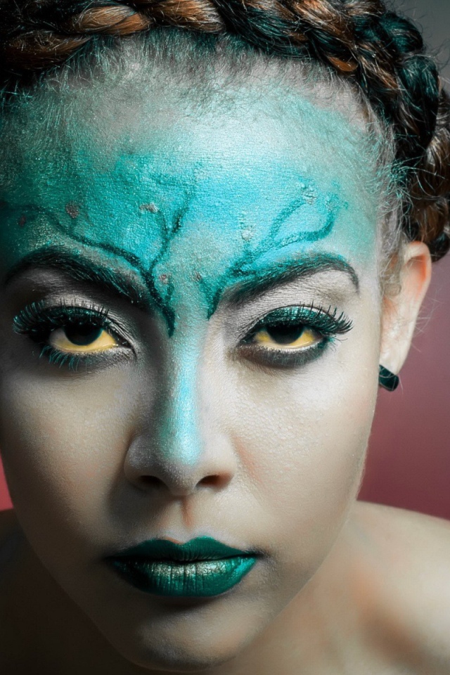 Зеленая краска на лице у девушки