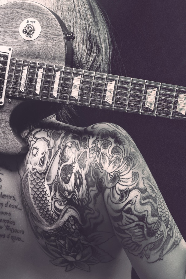 Гитара на спине татуированной девушки