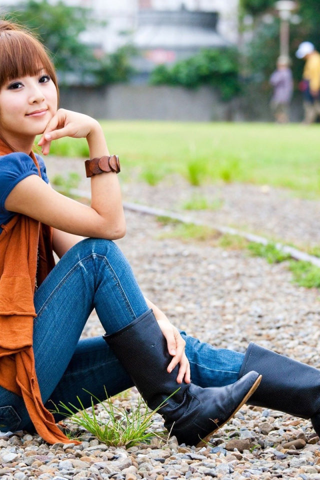 Японская девушка сидит на трамвайном пути