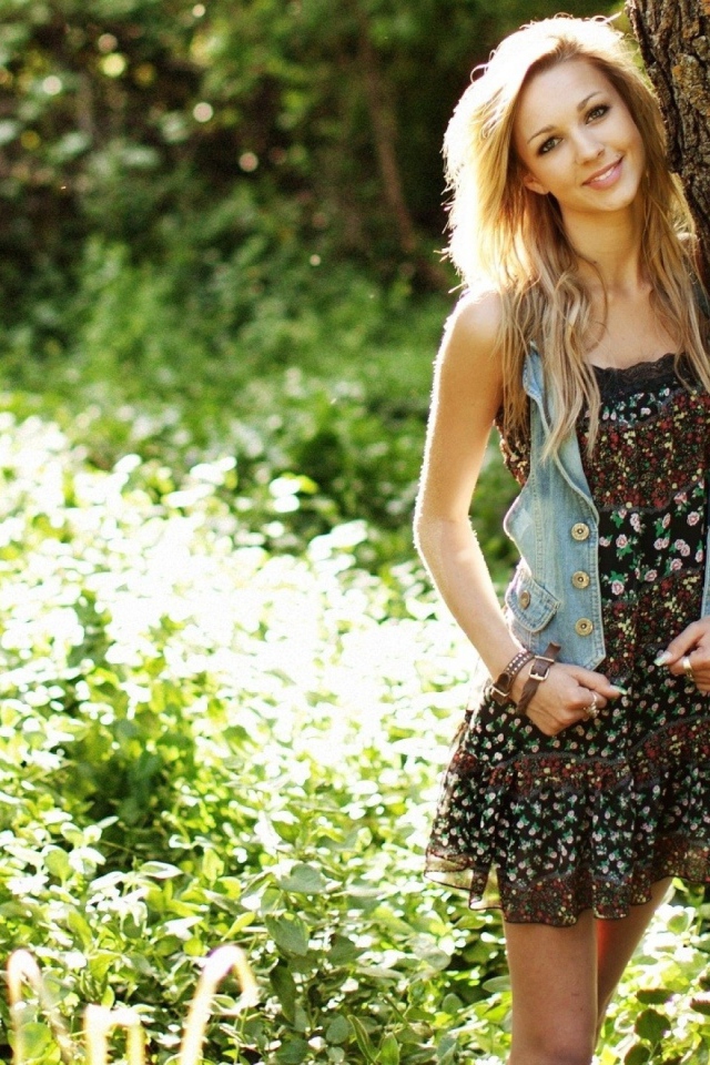 Милая блондинка прислонилась у дерева