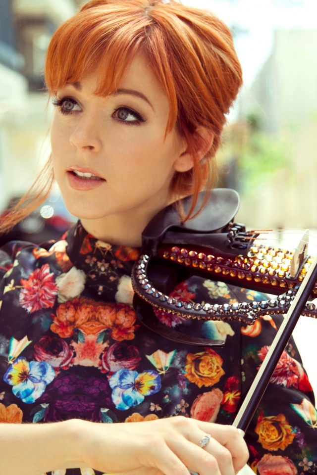 Рыжая девушка играет на скрипке со стразами