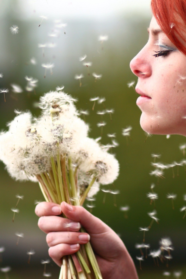 Рыжая девушка с букетом зрелых одуванчиков