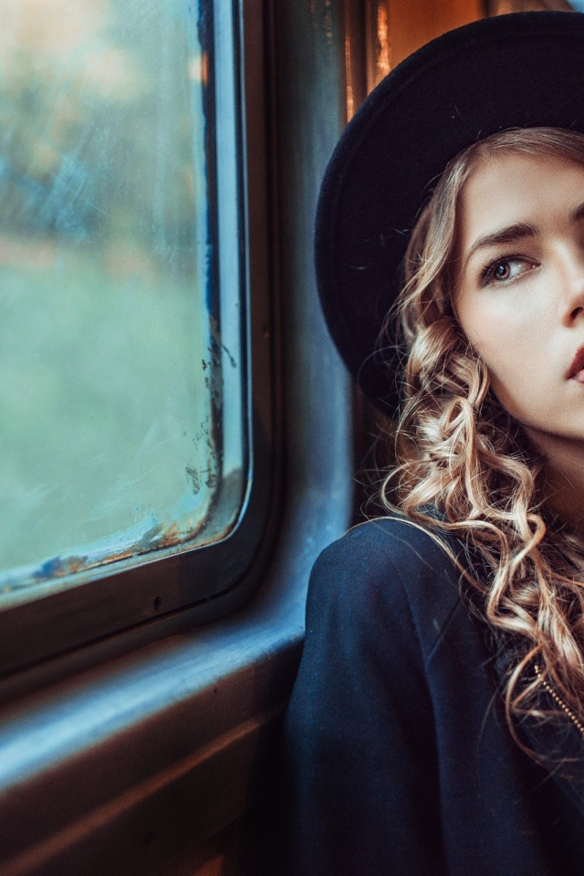 Романтичная девушка смотрит в окно