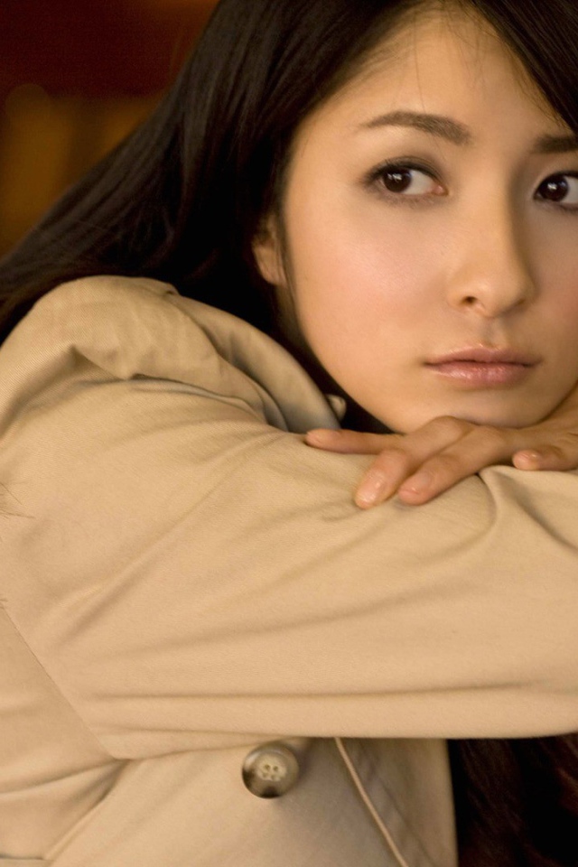 Грустная азиатская девушка в коричневом плаще