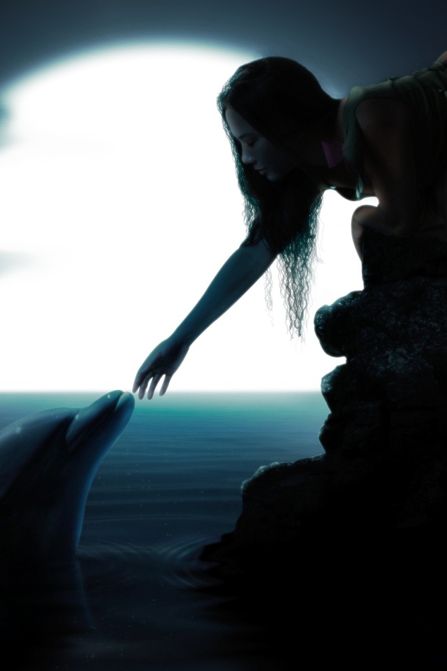 Девушка протянула руку к дельфину