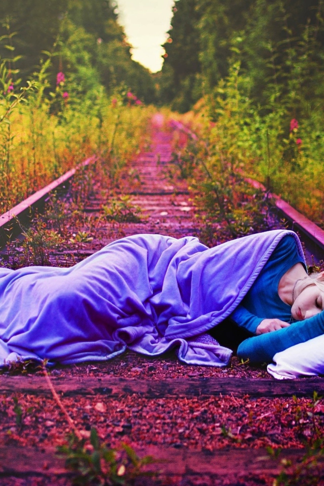 Девушка спит на заброшенных рельсах