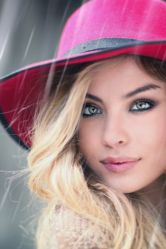 Блондинка в розовой шляпе под дождем
