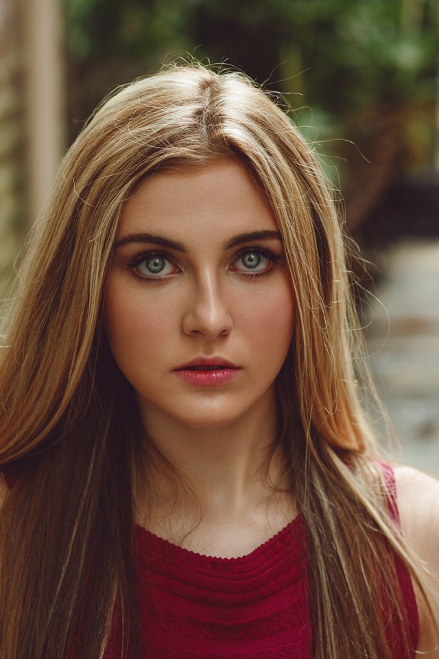 Блондинка с зелеными глазами идет по улице