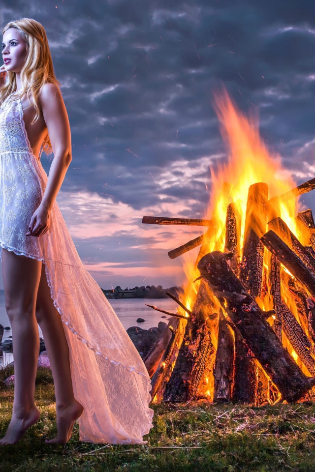 Девушка у костра на берегу океана