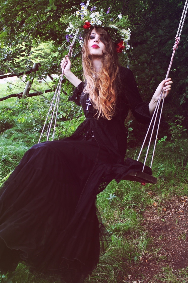 Девушка в черном платье на качели