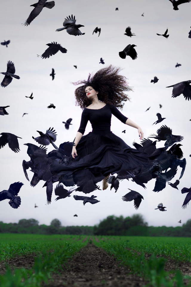 Девушка в черном платье парит среди ворон