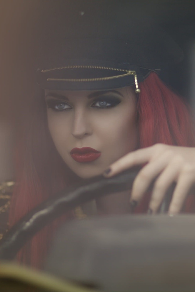 Девушка в фуражке за рулем