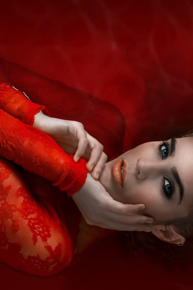 Девушка в красном кружевном платье на красном фоне