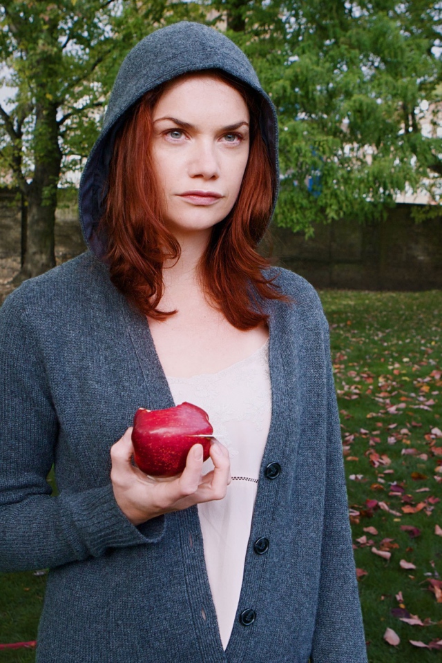 Девушка в капюшоне с яблоком