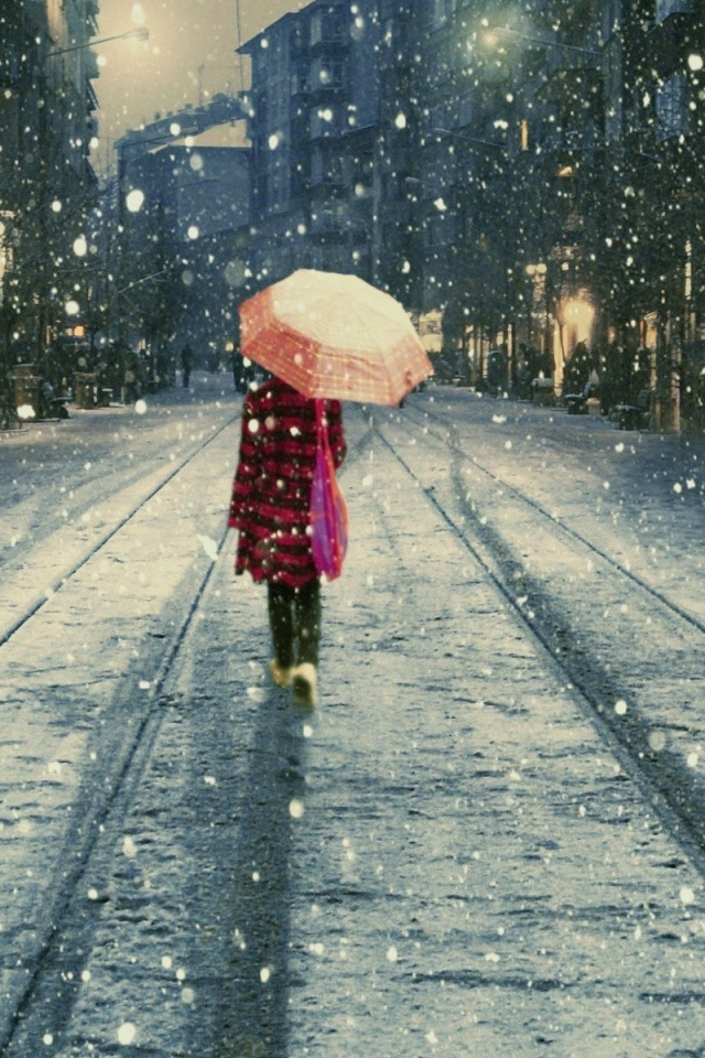 Девушка под дождем идет вдаль по улице