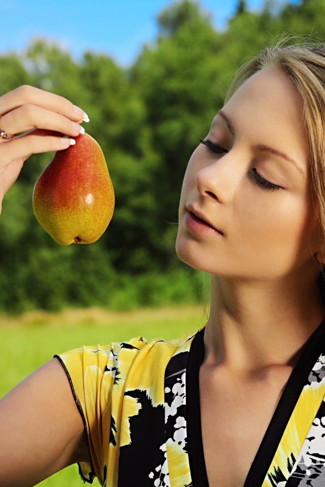 Девушка смотрит на грушу