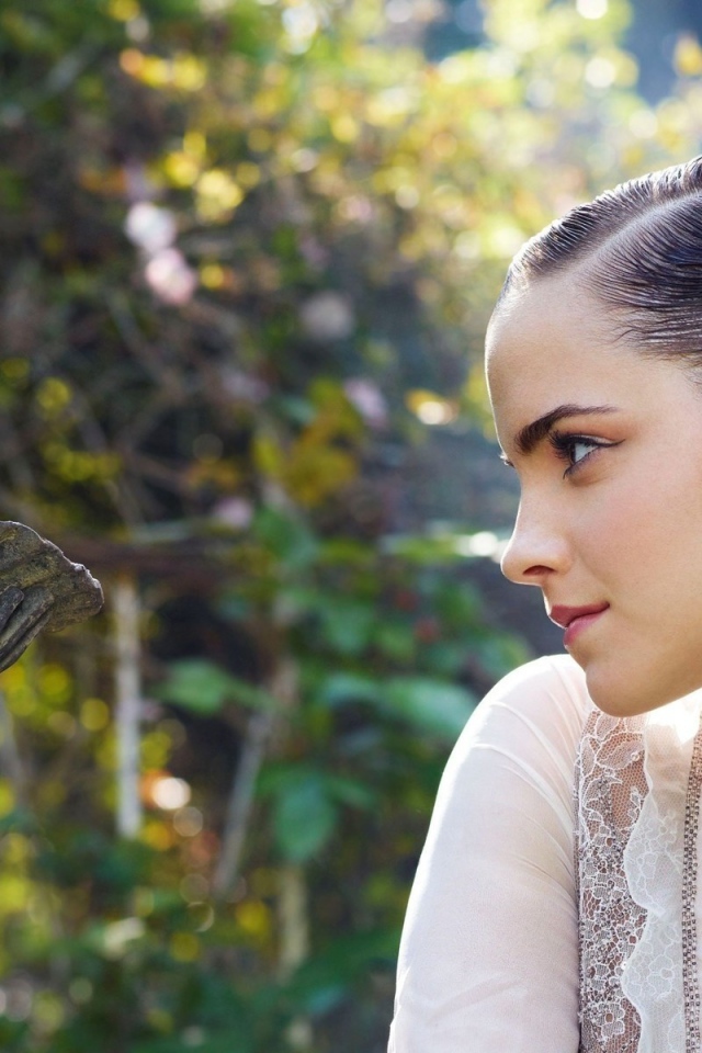 Девушка смотрит на скульптуру в саду