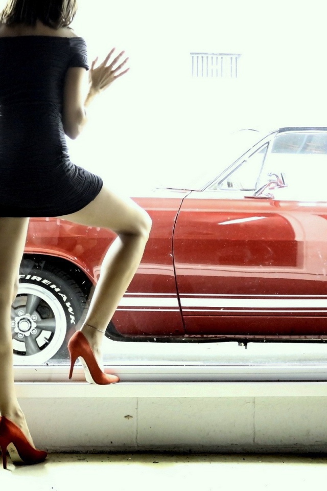 Девушка смотрит в окно на красный автомобиль