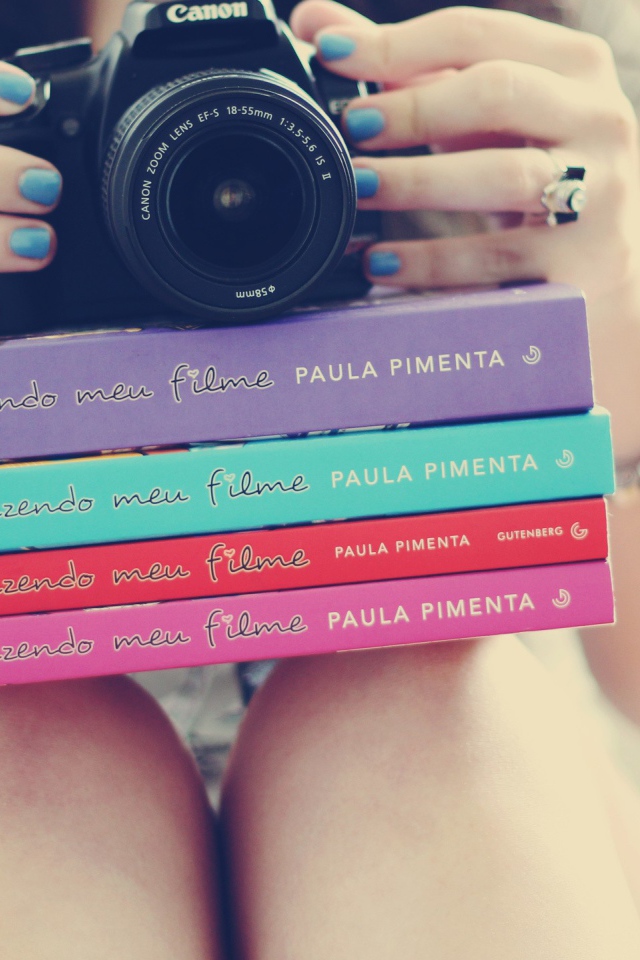 Девушка фотограф со стопкой книг