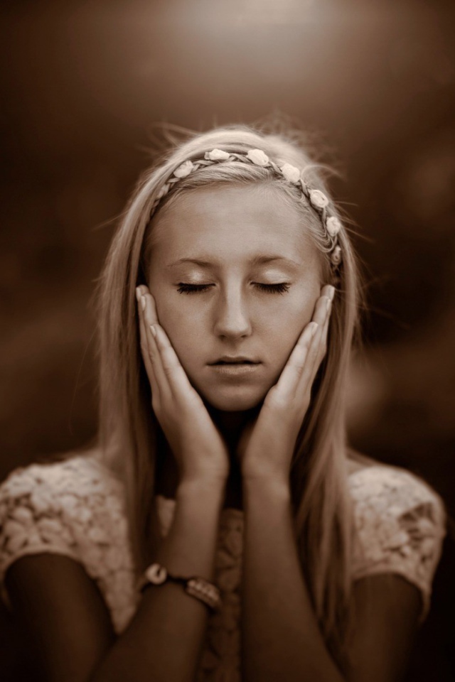 Девушка прикоснулась руками к лицу