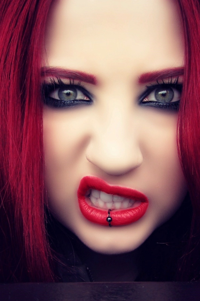 Девушка с красными волосами показывает зубы