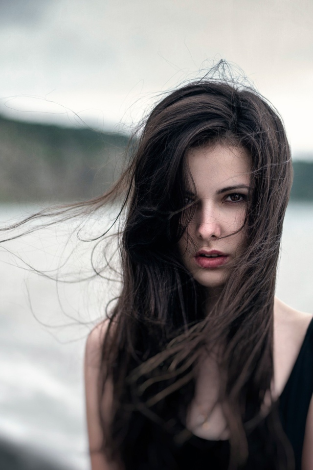 The wind ruffled the girl's hair by the sea, portrait