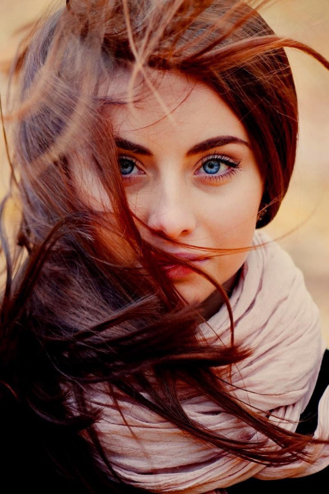 Ветер треплет волосы у девушки