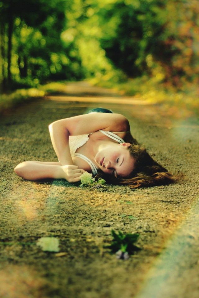 Женщина спит на лесной дороге