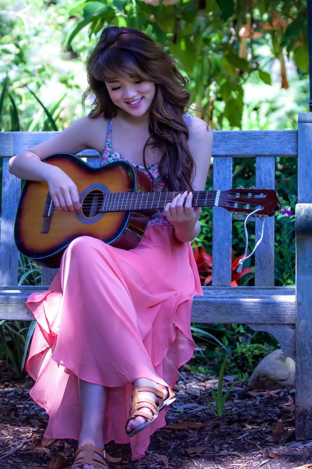 Девушка в розовом платье с гитарой