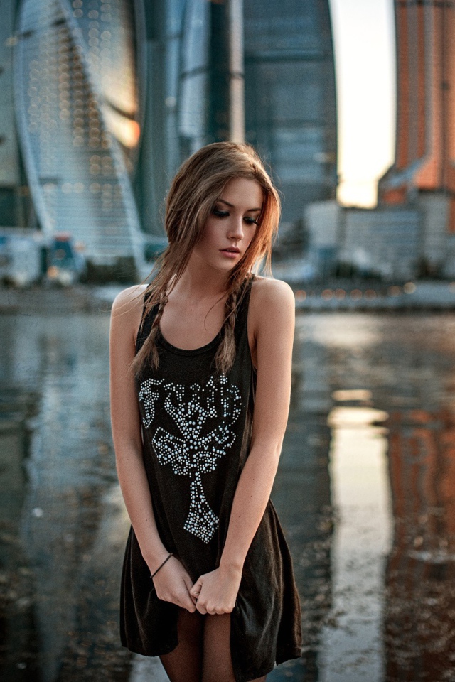 Модель на фоне реки и небоскребов