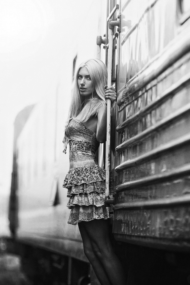 Модель стоит у входа в вагон, черно белое фото