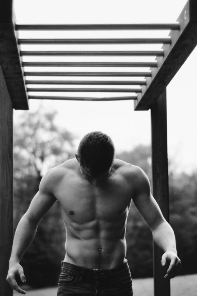 Мужчина занимается спортом на турнике