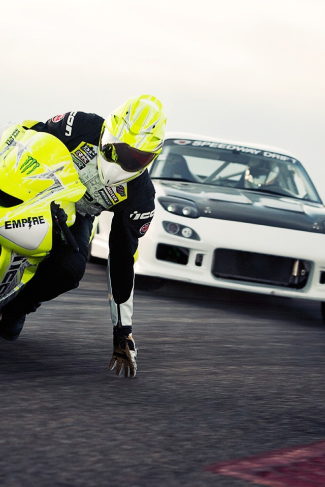 Мотоциклист касается рукой поверхности трека