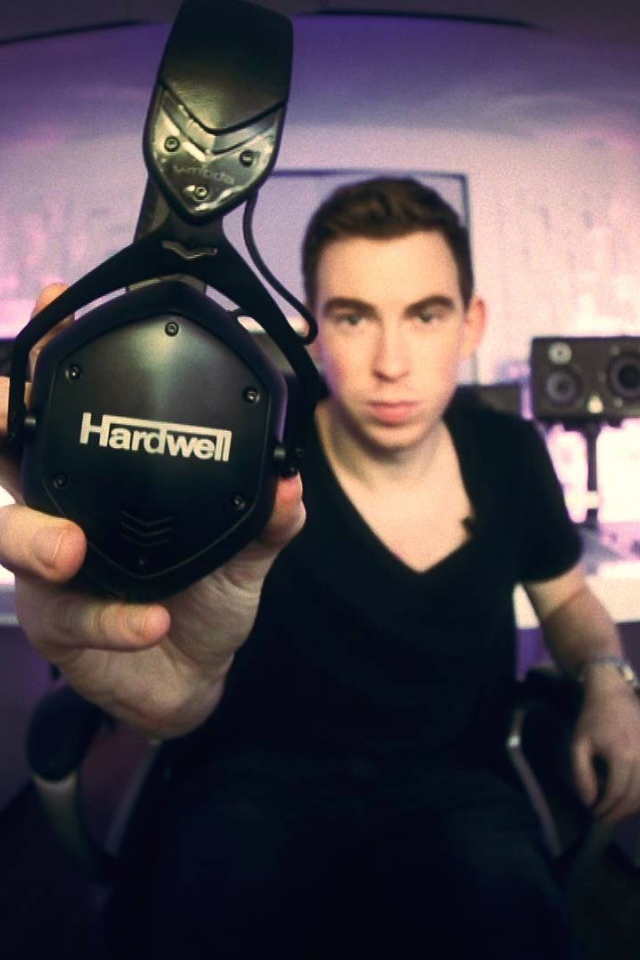 Музыкант держит в руке наушники Hardwell