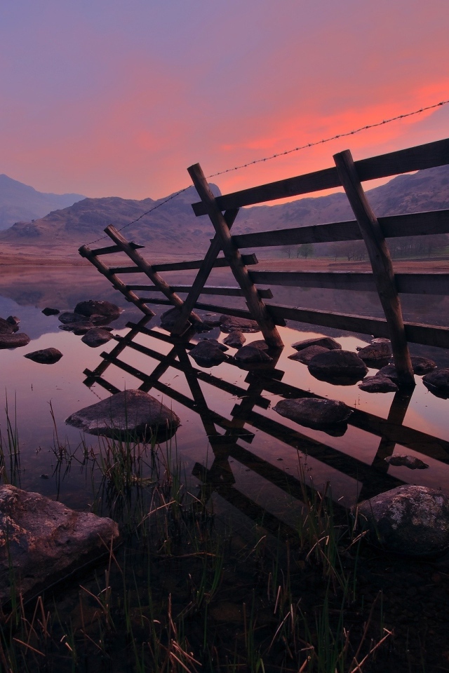 Полуразрушенный забор у воды