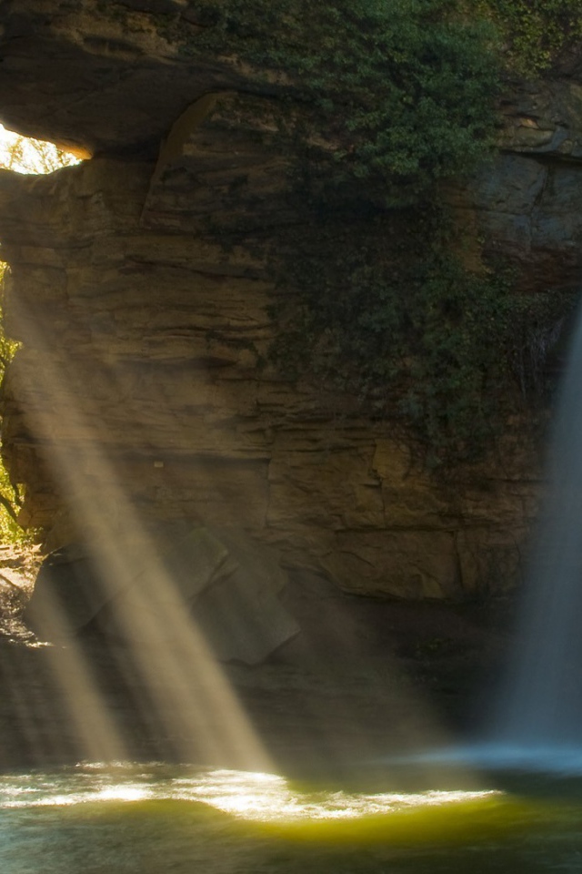Лучи солнца и вода падают в пещеру