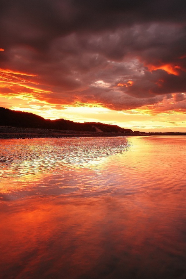 Камень на мелководье на фоне красного заката