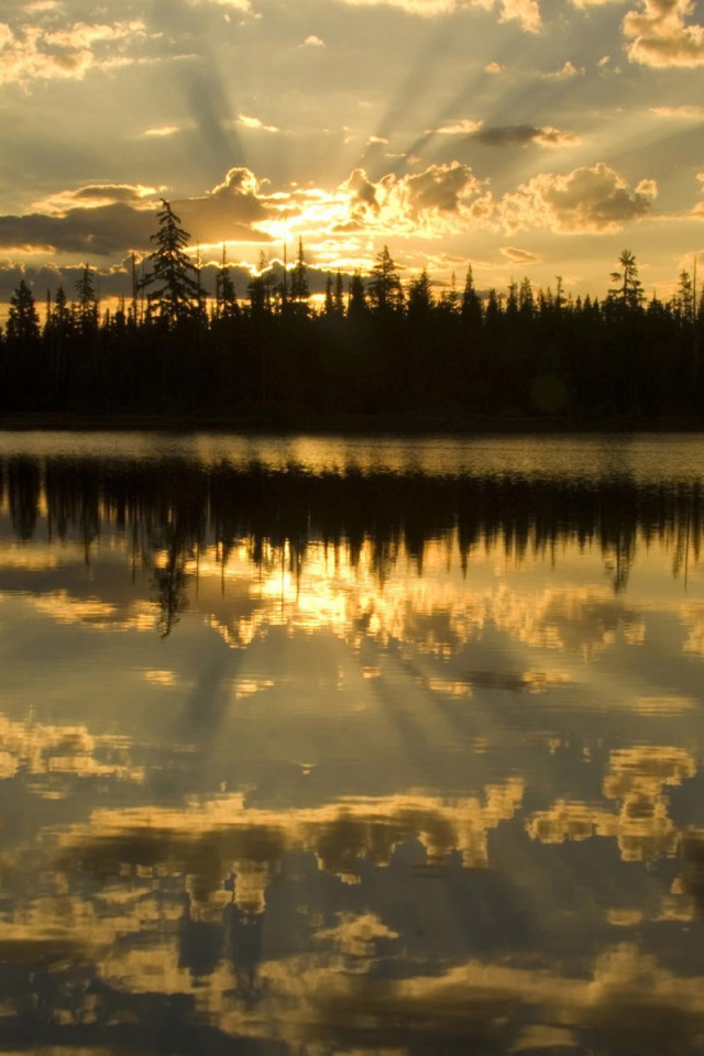 Освещенные лучами солнца облака отражаются в воде