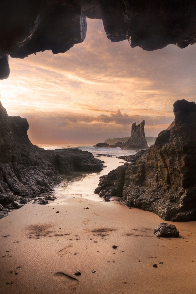 Мокрый песок у входа в пещеру