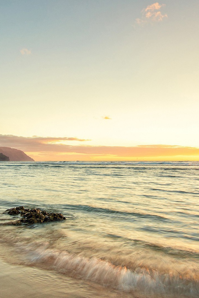 Волны прибоя накатывают на пляж