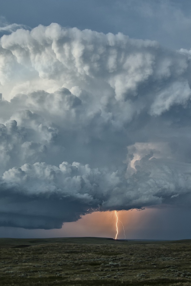 Оранжевая молния в огромном белом облаке