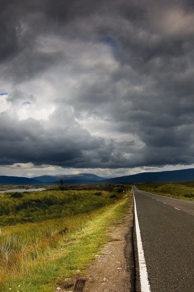Шоссе среди полей под мрачными облаками